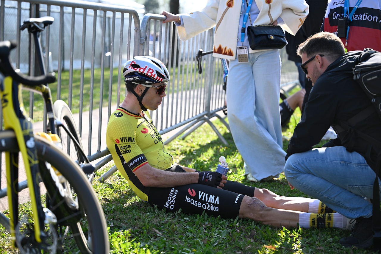 Wout van Aert seduto a terra dopo una gara, simbolo fatica e sconfitta nel ciclismo