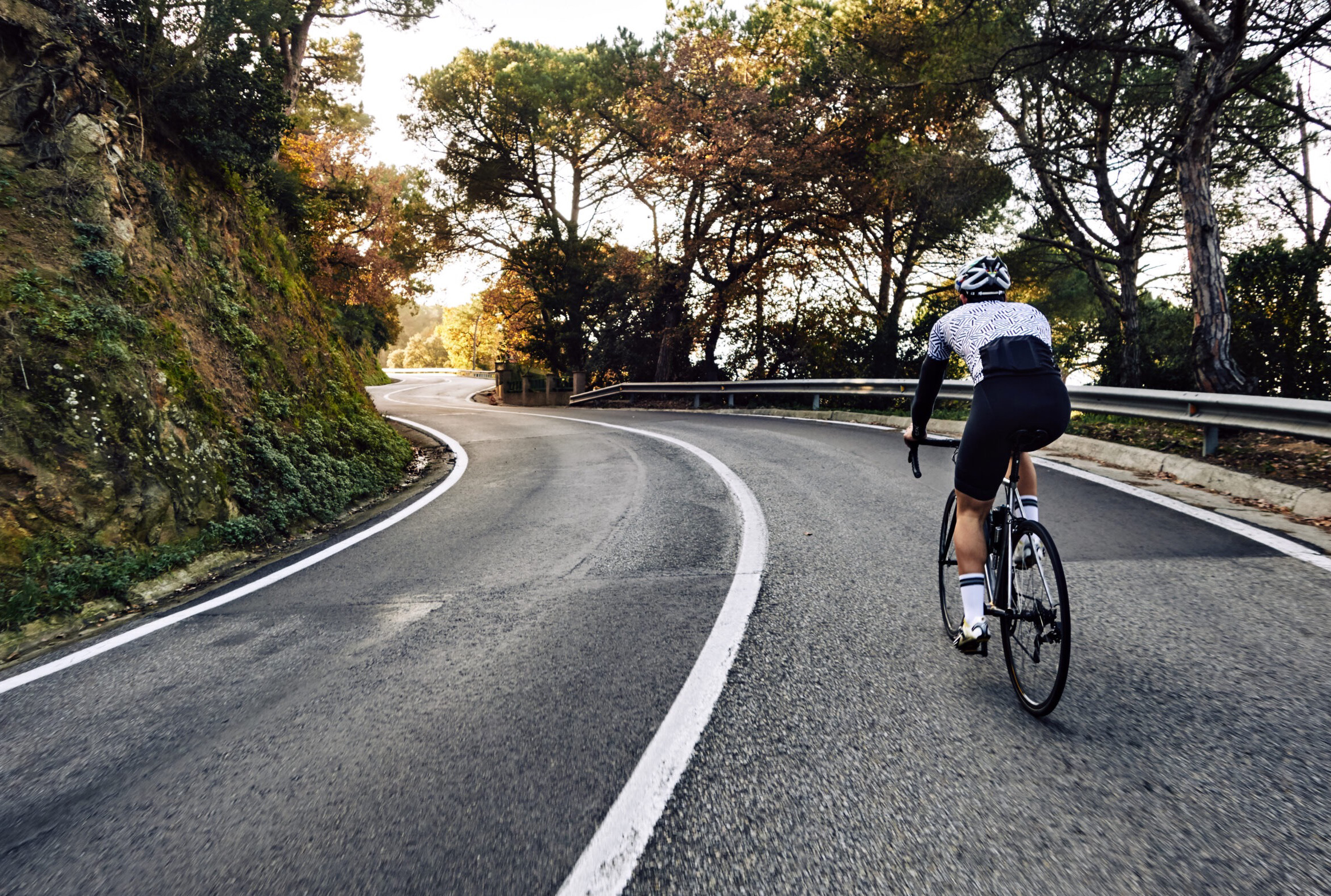 Ciclista su una lunga strada in salita